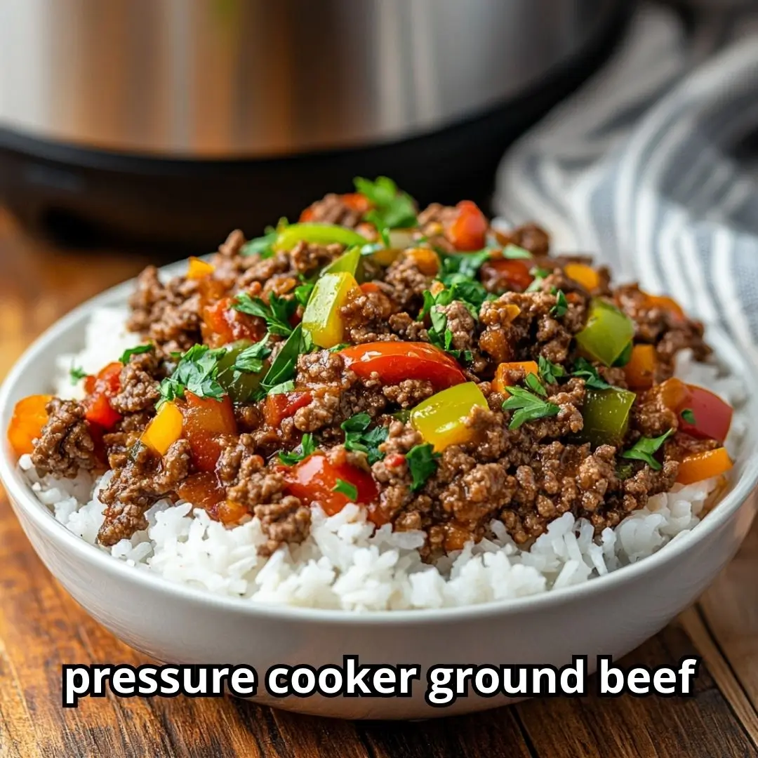Hearty bowl of cooked ground beef over rice with fresh herbs, next to a stainless steel pressure cooker ground beef on a rustic wooden table.